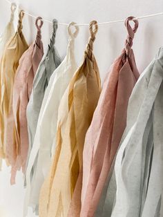 several different colored scarves hanging on a line