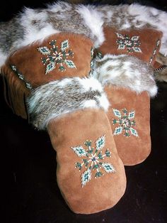 four pairs of slippers with snowflakes on them sitting on a black surface