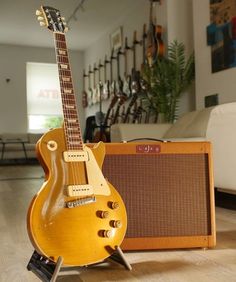 an electric guitar sitting on top of a wooden floor next to a speaker and amp