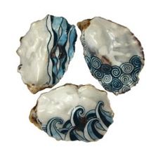 three seashells with blue and white designs on them