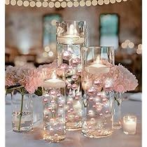 the centerpieces are filled with pink flowers and candles