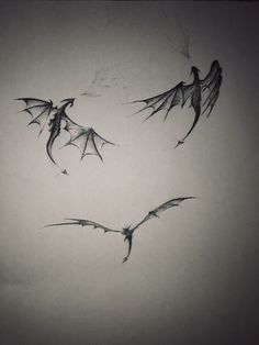 three bats flying in the air with their wings spread out to form a heart shape