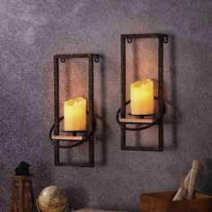 two wall sconces with lit candles on them