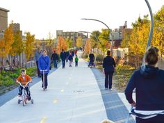 people are walking and riding bikes on the sidewalk