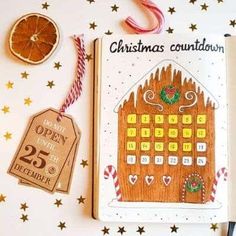 an open christmas countdown book next to some decorations and a slice of orange on a table