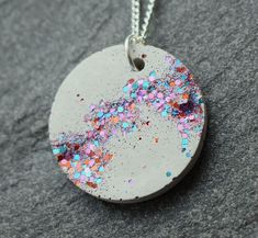 a white disc with multicolored sprinkles is sitting on a gray surface