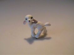 a small white toy dog sitting on top of a table