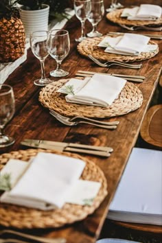 a wooden table topped with plates and glasses