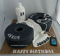 a birthday cake is decorated with two black and white cakes, one has a cell phone on it