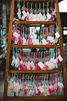 an old wooden ladder is filled with lots of tags and glasses hanging from it's sides