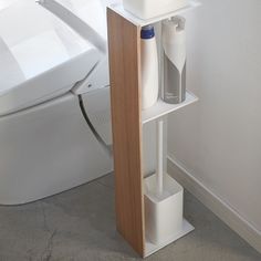 a bathroom with a toilet, sink and shelf next to the bathtub in it