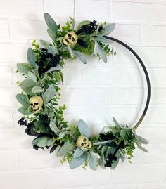 a wreath with green leaves and skulls on it