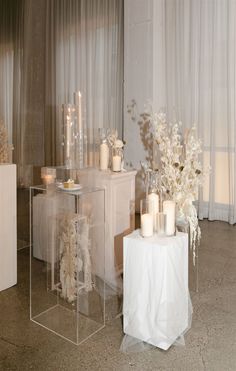 two clear tables with candles and flowers on them