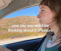 a woman sitting in the passenger seat of a car with a message written on it