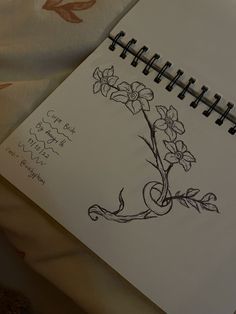 a drawing of a flower with vines and flowers on it, next to a notepad