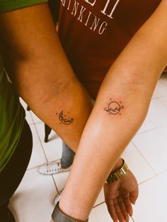 two people with matching tattoos on their arms