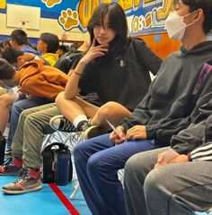 several people sitting in chairs with masks on their faces and one person wearing a face mask