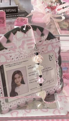 an id badge is attached to a clear case with pink ribbon and lace on it