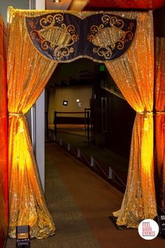 a gold and black stage set up for an event with drapes on the sides