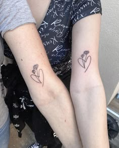 two people with matching tattoos on their arms