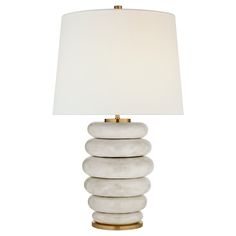 a white lamp sitting on top of a table next to a white lampshade