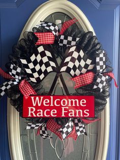 a welcome race fan wreath hanging on the front door with red and black checkered ribbon