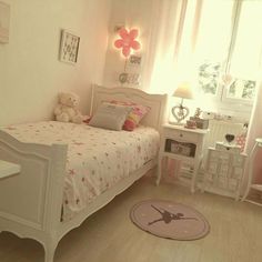 a bedroom with white furniture and pink decorations on the walls, along with a teddy bear