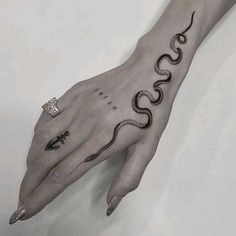 a woman's hand with a snake tattoo on it