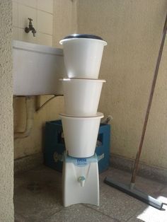 three white bowls stacked on top of each other in front of a sink and faucet