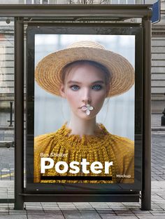 a poster on the side of a bus stop with a woman wearing a straw hat