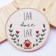 embroidered hoop with the words lar dolce lar and a birdhouse on it