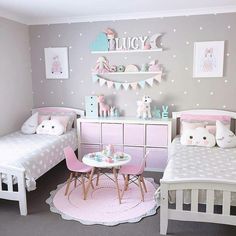 two beds in a room with pink and white decor on the walls, along with other furniture