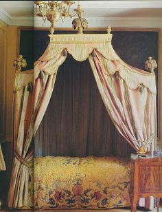 a bed with a canopy and curtains in a room