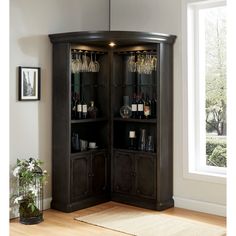 a tall wooden cabinet with wine glasses on it