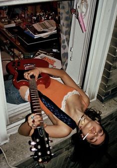 a woman laying on the ground with a guitar