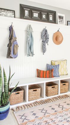 a white bench sitting next to a wall filled with baskets and hats on top of it