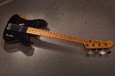 an electric bass guitar laying on the floor