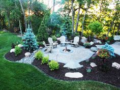 an outdoor fire pit surrounded by grass and trees