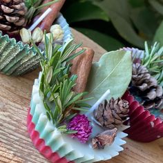 some cones are sitting on a table with pine cones and greenery in them,