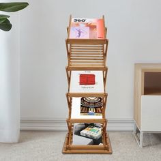 a bamboo magazine rack with magazines on it in the corner next to a white wall