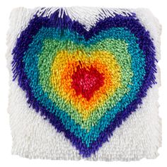 a multicolored heart shaped pillow on a white background