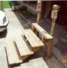 a wooden bench sitting next to a white car