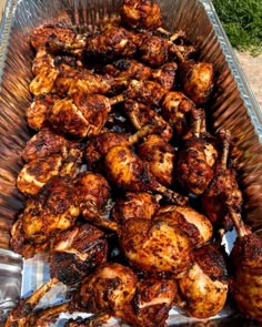 some chicken is sitting in a metal pan on the table and ready to be grilled