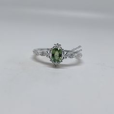 Band : Goldsmith Jewellers Material : 925 Sterling Silver Gemstone : Natural Green Sapphire Green Sapphire Stone Weight : 0.70 Carat Green Sapphire Stone Size : 6 x 4.10 MM Secondary Stone : Cubic Zirconia Zirconia Stone Weight : 0.12 Carat Zirconia Stone Size : 1.20 MM Gross Weight : 2.270 GM Stone Shape : Oval, Round Ring Size : All Size Available Made to Order Please Give Your Opinion or Feedback About The Product We make beautiful handmade jewelry. For any question please do not hesitate to contact us.  https://www.etsy.com/in-en/your/shops/GoldsmithJewellers/onboarding/listings/create Silver Green Ring, Green Sapphire Ring In Sterling Silver, Sterling Silver Ring With Prong Setting For May Birthstone, Green Sapphire Ring With Sterling Silver, Classic Silver Ring With Peridot, Classic Silver Peridot Rings, Sterling Silver Emerald Ring With Accent Stones For Promise, Green Oval Crystal Ring In Sterling Silver, Emerald Promise Ring With Accent Stones In Sterling Silver