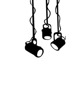 three black and white lamps hanging from the ceiling with cords attached to them, in front of a white background