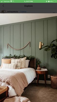 a bed sitting in a bedroom next to a green wall with wooden slats on it