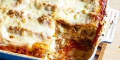 a casserole dish with meat, cheese and sauce in it on a wooden table