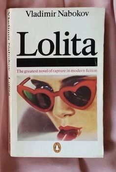 the book lollita is laying on a pink sheet