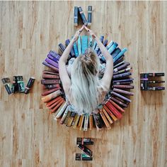 a woman standing in front of a wall made out of books