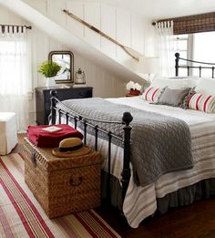 a bed room with a neatly made bed next to a window and a basket on the floor